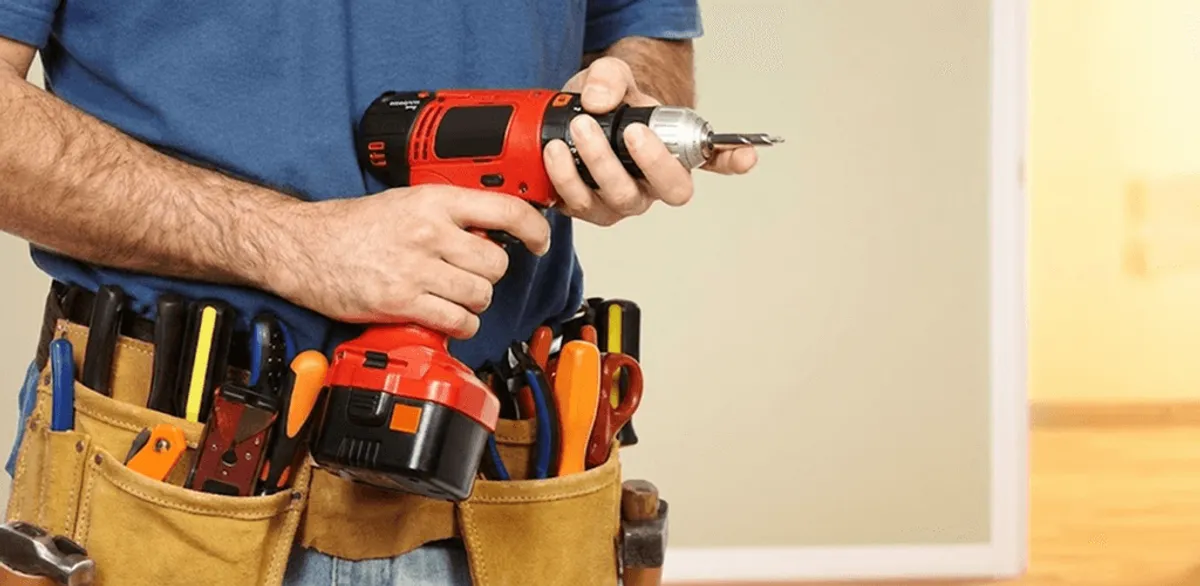 Handyman holding a power drill for home repairs and installations in Bellevue, WA